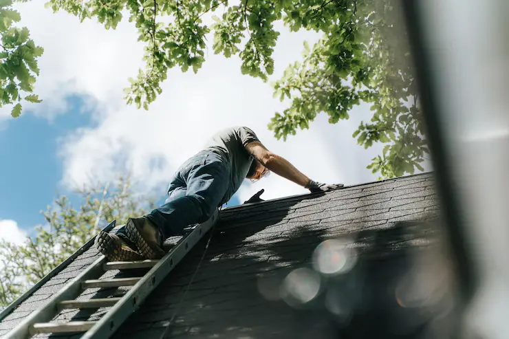 mann mot å klatre for å rengjøre tak
